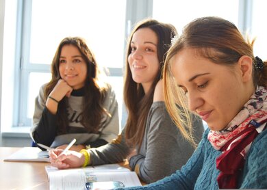 Drei Frauen sitzen gemeinsam am Tisch und haben Buecher mit vor ihnen und einen Stift in der Hand | © Pixabay