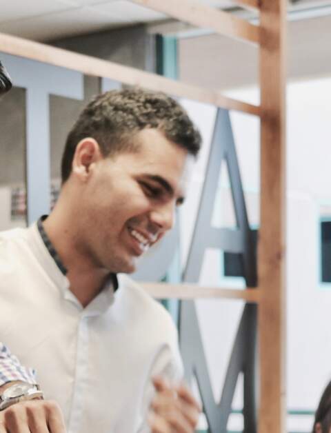 Eine Frau sitzt am Tisch vor einem Laptop, drei weitere Personen stehen neben ihr und schauen auf einen anderen Laptop | © Pixabay/CampaignCreators