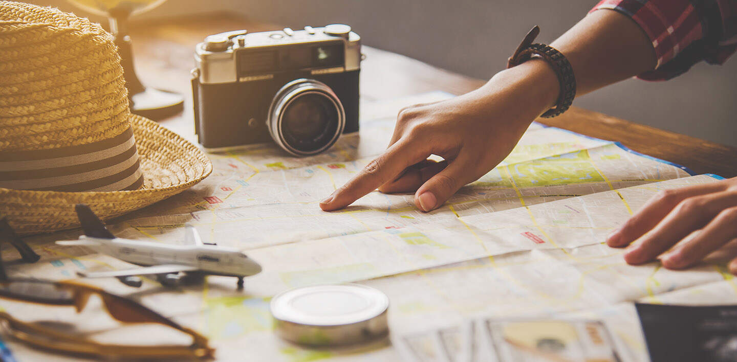 Reisende planen eine Reise, indem sie die Route auf der Karte | © Gettyimages.com/Photobyphotoboy